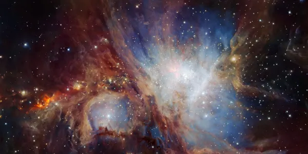 The Orion Nebula. A black background with clouds of blue, red and white, and some stars.