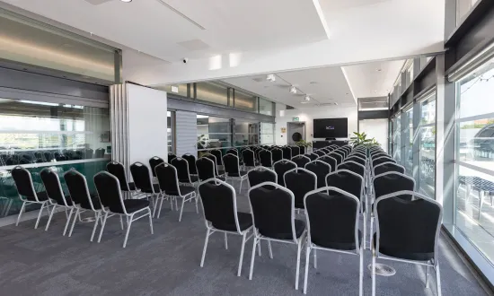 Conference style room with chairs in front of a screen. 