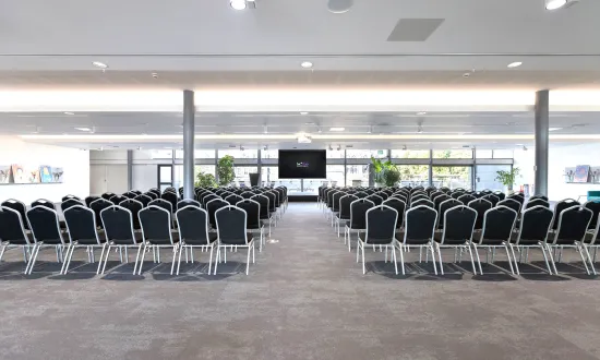 Conference style room with chairs in front of a screen. 