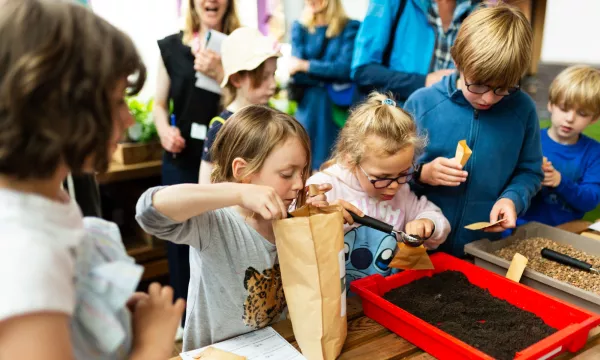 A group of children enjoying a hands on activity in the greenhouse exhibit