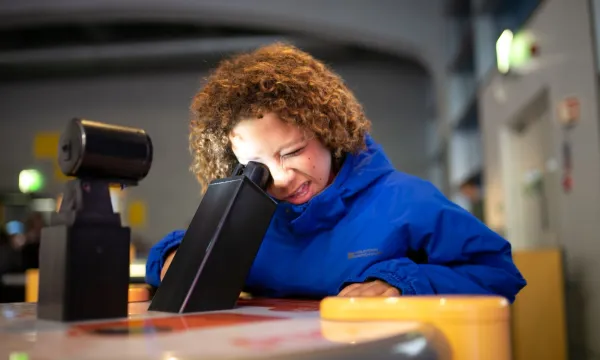 A child peering into a microscope 