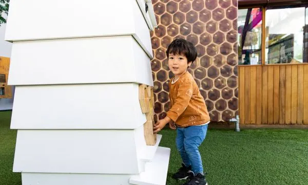 A content looking child playing with an interactive exhibit at We The Curious Bee Station 