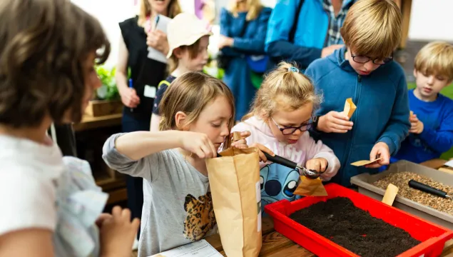 A group of children enjoying a hands on activity in the greenhouse exhibit 