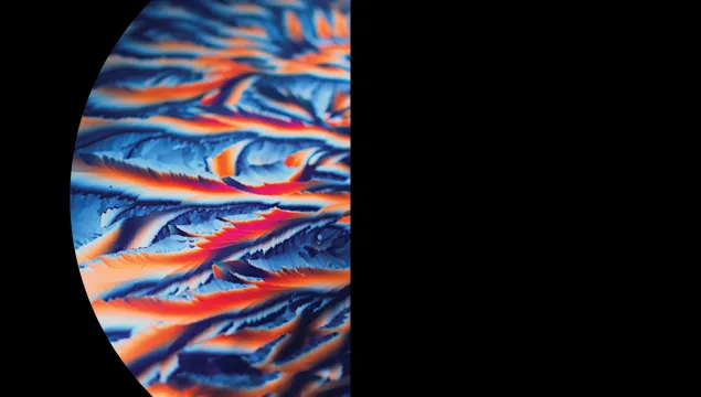 A semi-circle on a black background, featuring vibrant blue, orange, and red swirls