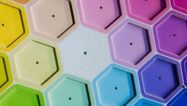 A number of hexagonal shapes are arranged in a rainbow format.