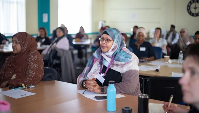 A person sitting at a table listening to a talk