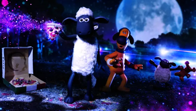 A screenshot from Aardman film - Shaun the Sheep, with a cartoon sheep and a dog stood in a field holding a glowing slice of pizza