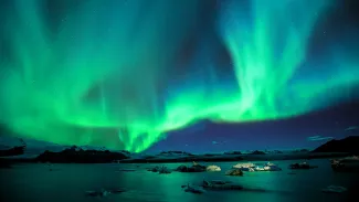 The Aurora Borealis, with blues and greens over a lake.