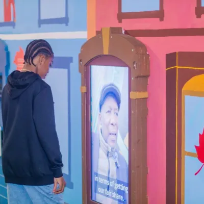 A visitor looking at one of the video installations in the Street Scene mural  