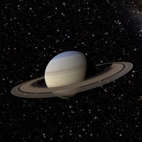 Saturn and its rings in front of a dark night sky with stars.