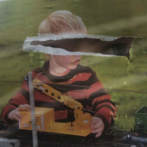 A ripped photograph of child boywith eyes showing through