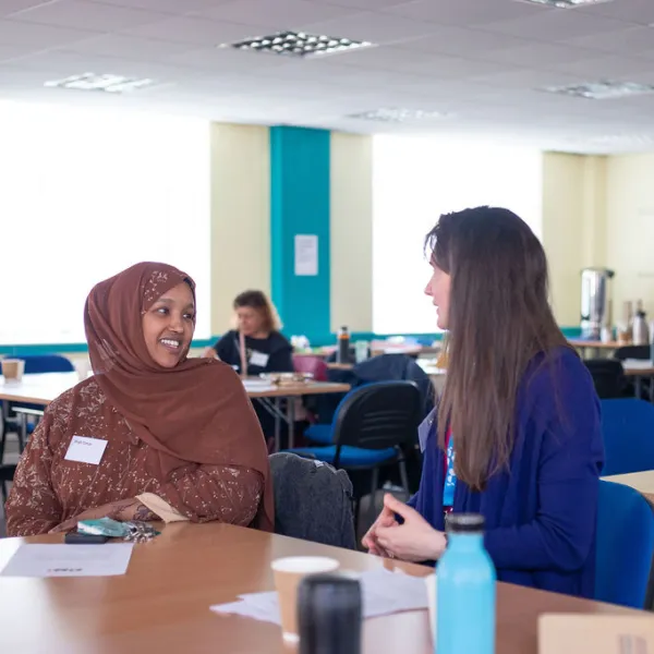 Two people smiling and having a conversation