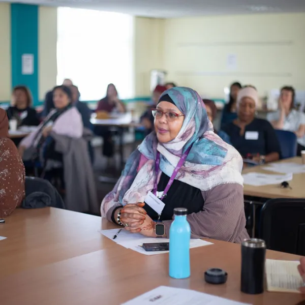A person sitting at a table listening to a talk