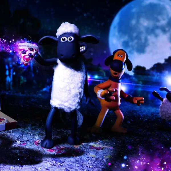 A screenshot from Aardman film - Shaun the Sheep, with a cartoon sheep and a dog stood in a field holding a glowing slice of pizza